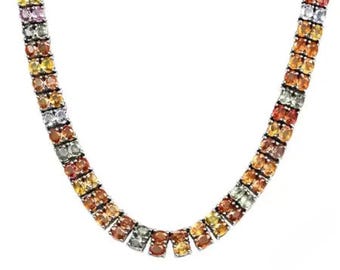 May include: A multi-colored gemstone necklace with a gradient of colors, including orange, yellow, pink, and gray. The necklace is composed of small, round gemstones set closely together in a double-row design. The gemstones are set in a silver metal.