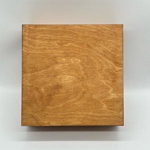 May include: A close-up of a wooden surface stained in a chestnut colour. The surface has a wood grain pattern and appears to have been finished with two coats of stain.
