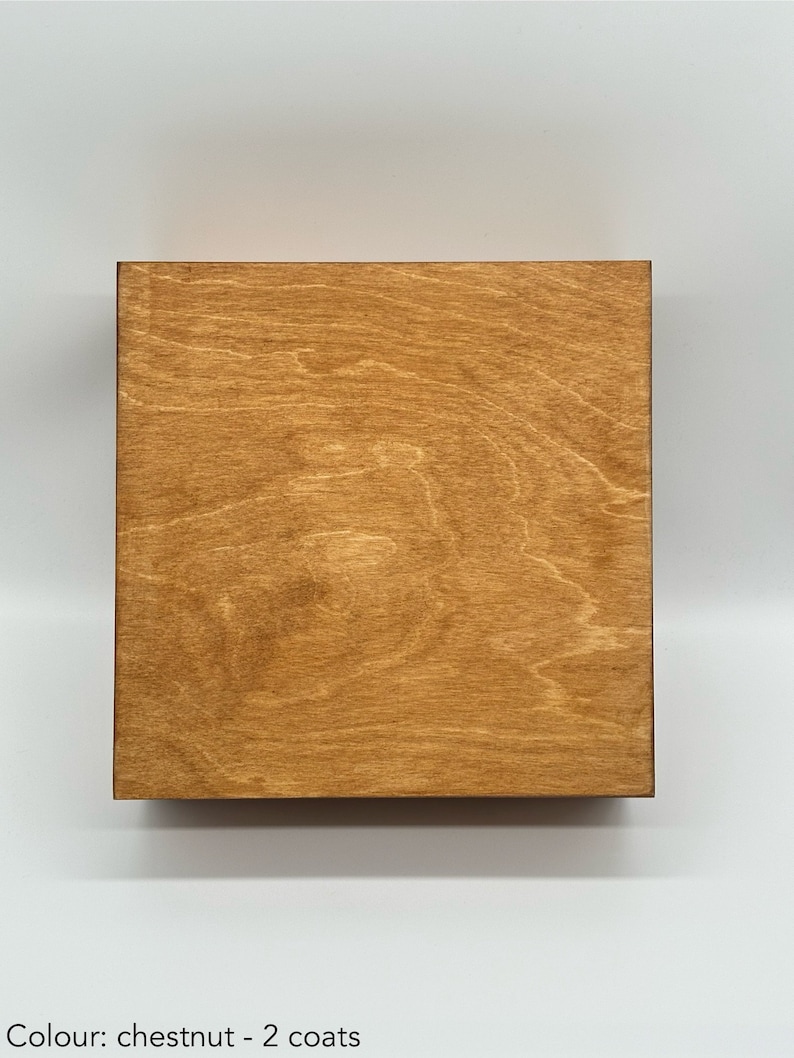 May include: A close-up of a wooden surface stained in a chestnut colour. The surface has a wood grain pattern and appears to have been finished with two coats of stain.