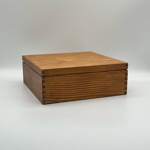 May include: A wooden box with a chestnut stain and two coats of finish. The box has a lid and is made of wood with a natural grain pattern.