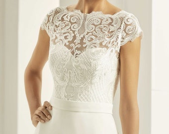 May include: A white wedding dress with a lace overlay bodice and a simple skirt.