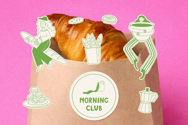 Pu&ograve; includere: Un sacchetto di carta marrone pieno di un croissant. Illustrazioni verdi e bianche di articoli per la colazione e persone sono poste attorno alla borsa. Un adesivo rotondo con le parole "MORNING CLUB" &egrave; sulla borsa. Lo sfondo &egrave; rosa.
