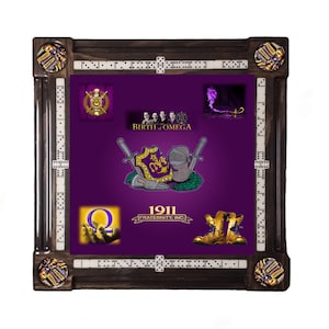 May include: A purple and gold domino table with a variety of images including a shield with the letters "Q.I.A." and the text "1911 Fraternity, Inc."