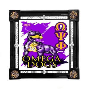 May include: Black framed domino set with a purple and yellow dog graphic, the text "OMEGA DOGS", and Greek letters. The set includes dominoes and decorative corner pieces.