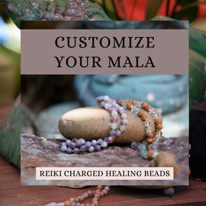 Pode incluir: Personalize o seu Mala - Contas de cura carregadas de Reiki. Close-up de três fios de contas de mala, feitas de várias pedras e madeira, descansando sobre uma rocha. As contas são roxas, brancas e marrons.