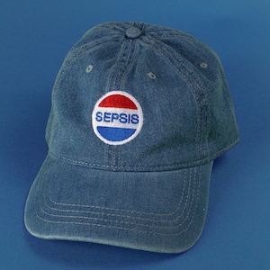May include: A blue denim baseball cap with a red, white, and blue circular patch that says "SEPSIS" in white letters.