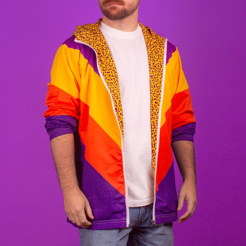 Pu&ograve; includere: Giacca retr&ograve; dai colori vivaci con un design a blocchi di colore. La giacca presenta una combinazione di pannelli arancioni, gialli e viola, con fodera e cappuccio con stampa leopardata. Ha una cerniera completa e un interno bianco.
