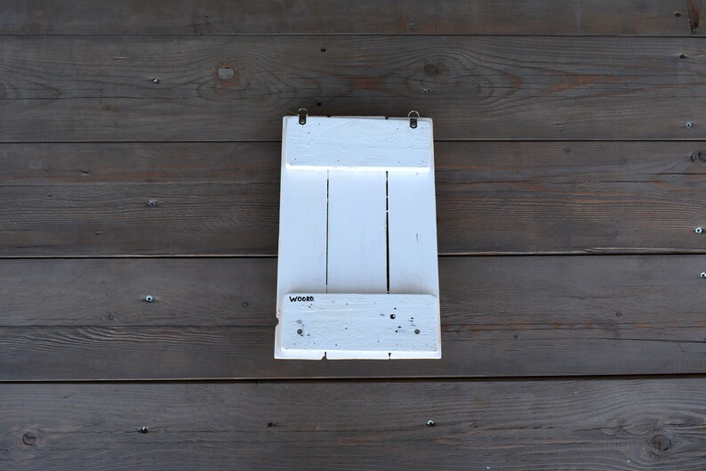 May include: White wooden wall shelf with three shelves and the word "Wooden" printed on the bottom shelf.