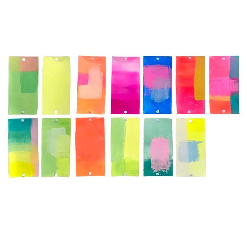 May include: A set of 12 colorful abstract paintings on paper, each with a different color scheme and brushstroke style. The paintings are arranged in two rows of six, and each painting is mounted on a white background.