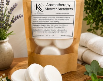 May include: A brown paper pouch containing white, round aromatherapy shower steamers. The label reads Aromatherapy Shower Steamers, scented: Peppermint, with ingredients and usage instructions listed. The net weight is 7.5 oz.