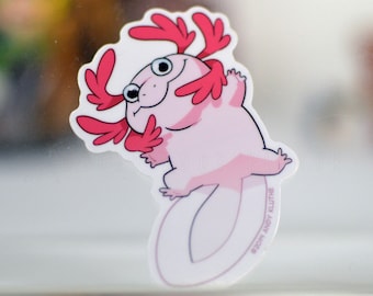May include: A pink axolotl with red gills, smiling and holding its arms up in a hug. The axolotl is on a white background with the text "2019 ANDY KLUTHE" at the bottom.