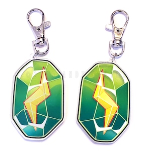 May include: Two green and yellow lightning bolt keychains with silver metal clasps. The keychains are shaped like a faceted gem.