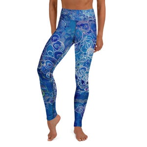 May include: High-waisted leggings featuring an abstract pattern in various shades of blue. The design includes intricate white line work resembling circular and floral motifs layered over a textured, deep blue background across the entire garment.