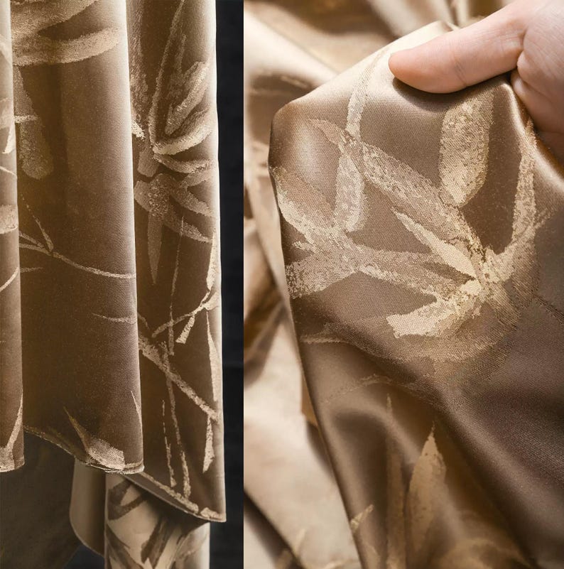 Puede incluir: Primer plano de una tela lujosa drapeada en tonos marrones y beige. La tela presenta un patr&oacute;n repetido de dise&ntilde;os estilizados de hojas o flores de color claro. El material tiene un brillo sutil, lo que sugiere un tejido de seda o sat&eacute;n, y probablemente se utiliza para cortinas o tapicer&iacute;a.