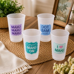 K&ouml;nnte beinhalten: Vier durchscheinende Kunststoffbecher mit bunten Etiketten und Text zum Thema Mahjong. Ein Becher zeigt MAHJ MAHJ MAHJ in Lila, einer DOT BAM crack in Blau, einer get your MAHJ ON in T&uuml;rkis und einer I heart MAHJ in T&uuml;rkis mit einem rosa Herz.