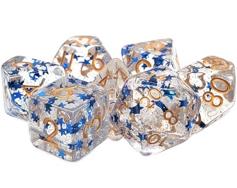 May include: A set of seven clear dice with blue glitter and gold numbers and stars. The dice are in a pile on a white background.