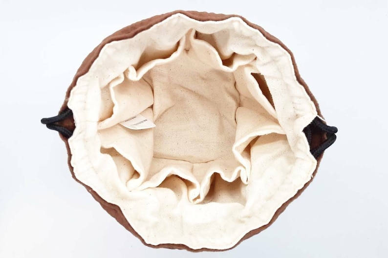 May include: A brown drawstring bag with a white cotton lining. The bag has a drawstring closure and is made of a soft, durable fabric.
