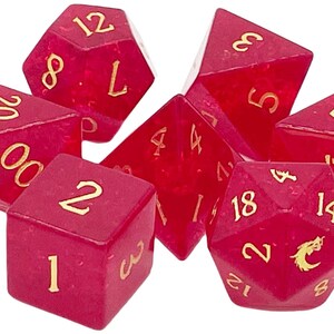 May include: A set of seven red dice with gold numbers and symbols. The dice are made of a translucent material and have a speckled appearance. The numbers on the dice are 1, 2, 3, 4, 5, 8, 12, 14, 18, 20.