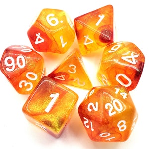 May include: Set of six orange and yellow dice with white numbers. The dice are translucent and have a glittery finish.