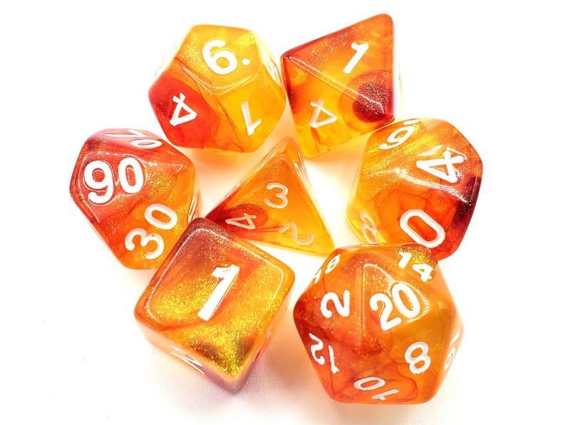 May include: Set of six orange and yellow dice with white numbers. The dice are translucent and have a glittery finish.