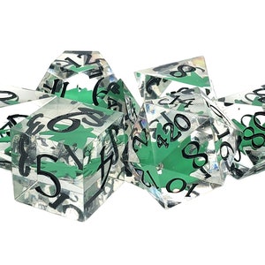 May include: A set of six clear dice with green and black ink. The dice are numbered 1 through 6, 8, 10, 12, and 20.