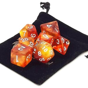 May include: A set of seven polyhedral dice in a black velvet bag. The dice are translucent and have a red and yellow swirl pattern. The numbers on the dice are white.