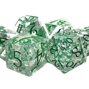 May include: Set of seven green and silver dice with silver flecks embedded in the clear plastic. The dice are numbered 4, 6, 8, 10, 12, 14, and 20.