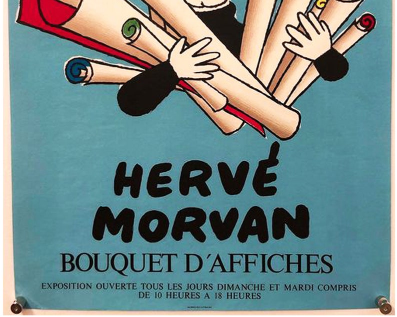 Puede incluir: Un cartel azul y blanco que anuncia una exposici&oacute;n de carteles de Herv&eacute; Morvan. El cartel presenta una ilustraci&oacute;n de dibujos animados de una persona que sostiene un ramo de carteles enrollados. El texto en el cartel dice "Herv&eacute; Morvan Bouquet d'Affiches Exposition ouverte tous les jours dimanche et mardi compris de 10 heures &agrave; 18 heures."