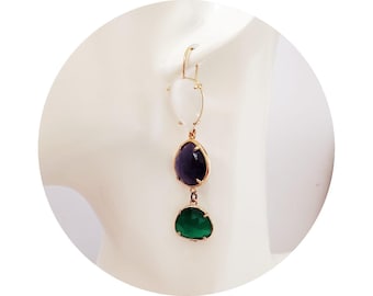 May include: Gold-coloured drop earrings with three teardrop-shaped stones in white, dark purple, and green. The stones are set in gold-coloured metal and hang from a simple hook.