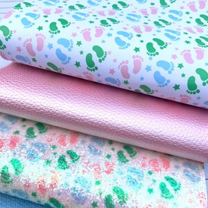 May include: Four different fabric swatches, stacked on top of each other. The top swatch is white with a repeating pattern of green and blue footprints and white stars. The second swatch is a light pink faux leather. The third swatch is a white fabric with a light blue and pink glitter pattern. The bottom swatch is a light blue faux leather.