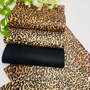 May include: Four sheets of fabric with a leopard print pattern. The fabric is in shades of brown, black, and tan. The fabric is arranged in a stack, with the top sheet folded over the bottom sheet.