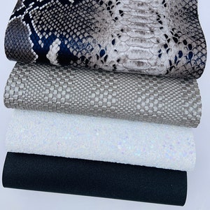 May include: A stack of four different fabric sheets. The top sheet is a faux snakeskin pattern in shades of gray and blue. The second sheet is a textured gray fabric. The third sheet is a white fabric with iridescent glitter. The bottom sheet is a solid black fabric.
