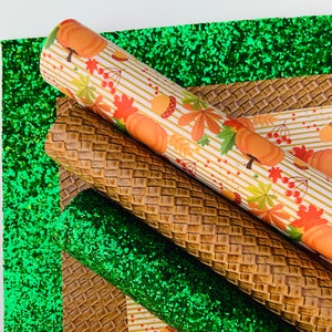 May include: An assortment of fall-themed craft materials. Rolls of patterned faux leather with pumpkins, leaves, and acorns, alongside textured brown and green glitter sheets. Ideal for seasonal crafting projects.