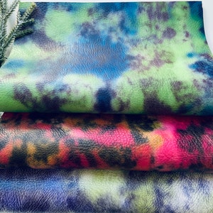 Puede incluir: Tres piezas de cuero sint&eacute;tico tie-dye en colores verde, rojo y azul. El cuero tiene una superficie texturizada.