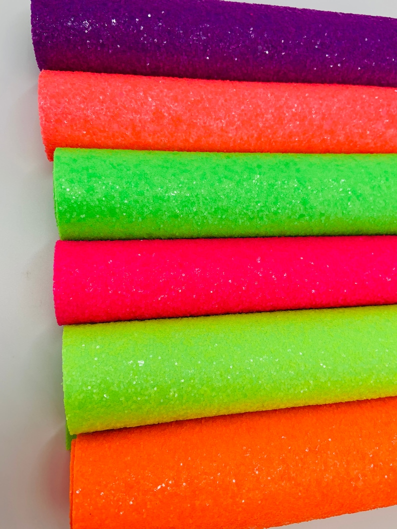Pu&ograve; includere: Un rotolo di tessuto glitterato in sei diversi colori neon, tra cui viola, arancione, verde, rosa, verde lime e arancione.