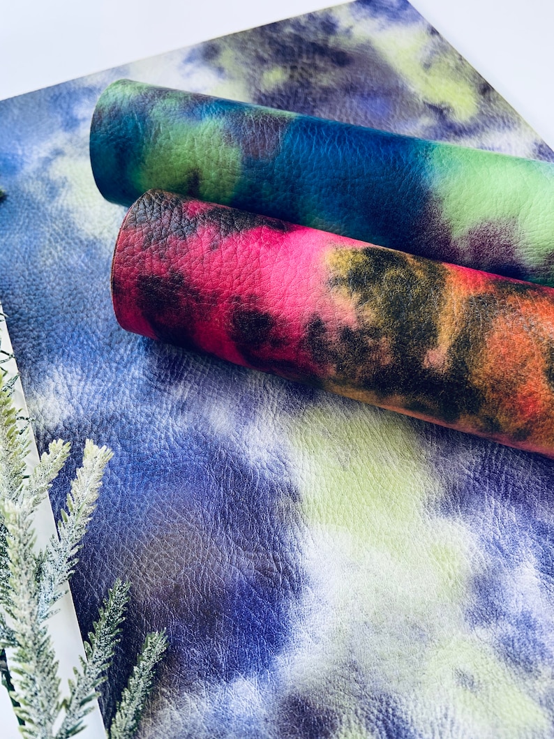 Puede incluir: Dos piezas de tela te&ntilde;ida anudada en azul, verde y rosa sobre un fondo blanco. La tela est&aacute; doblada y los bordes son visibles.