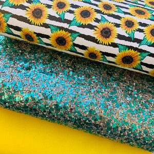 May include: Three sheets of fabric: a black and white striped fabric with a sunflower pattern, a green glitter fabric, and a solid yellow fabric.