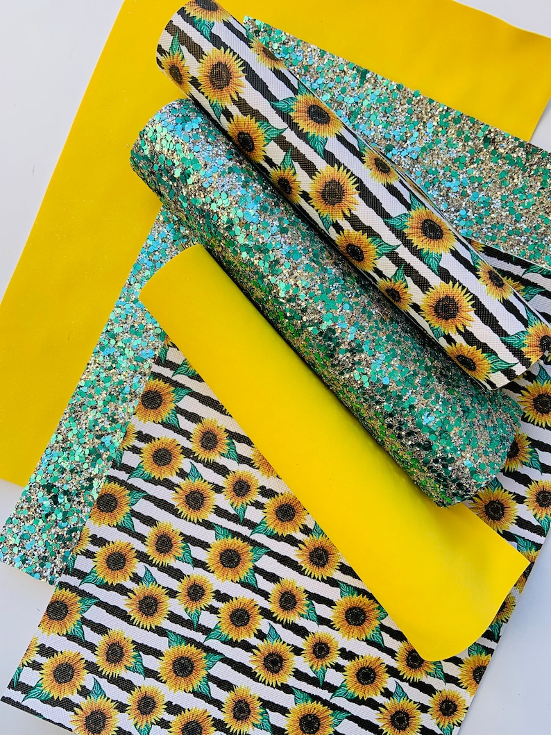 May include: A set of four fabric sheets featuring a sunflower pattern. The sheets are in black and white stripes with yellow sunflowers. One sheet is solid yellow, and another is a green and silver glitter fabric.