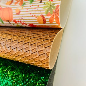 May include: Close-up of three different textured sheets. The top sheet has a fall-themed pattern with pumpkins, leaves, and acorns. The middle sheet is brown with a woven pattern. The bottom sheet is covered in green glitter.