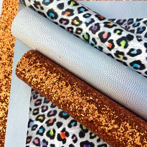 May include: A set of four craft supplies featuring a white and black leopard print with rainbow accents, a white iridescent faux leather, and a copper glitter fabric.