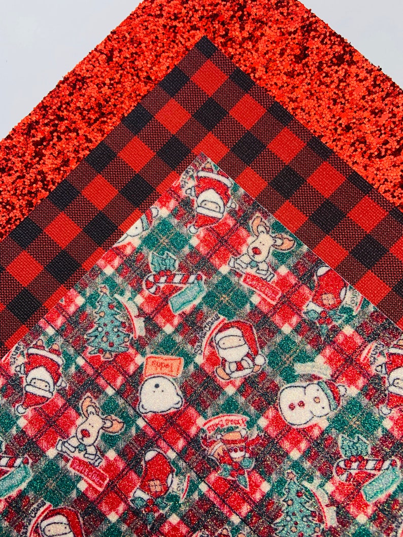 May include: Red and black buffalo plaid fabric with a red glitter fabric and a red and green plaid fabric with a Christmas theme featuring Santa, reindeer, snowmen, and Christmas trees.