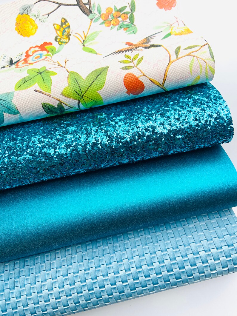May include: Four different fabric swatches in shades of blue. The top swatch features a white background with a floral pattern, the second swatch is a sparkly turquoise blue, the third swatch is a solid turquoise blue, and the bottom swatch is a textured light blue.