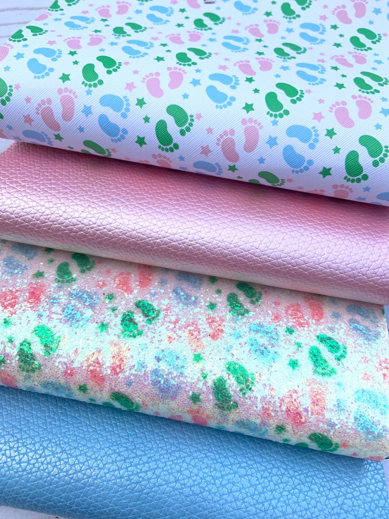 May include: Four fabric swatches, each with a different pattern. The top swatch is white with green and pink footprints and white stars. The second swatch is a solid pink with a textured surface. The third swatch is white with a pink, green, and blue glitter pattern. The bottom swatch is a solid light blue with a textured surface.