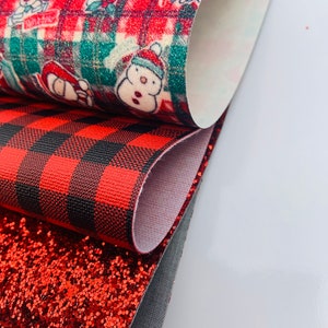 May include: Three red and black patterned fabric sheets. The top sheet features a red and green plaid pattern with a white background and a repeating pattern of Christmas characters. The middle sheet is a red and black buffalo plaid pattern. The bottom sheet is a red glitter fabric.