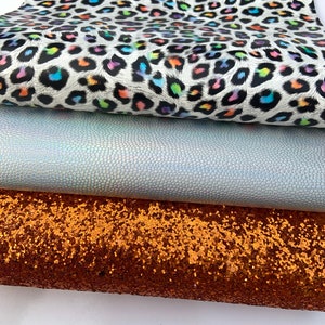 May include: Three fabric swatches: a white fabric with a rainbow leopard print, a light blue iridescent fabric with a textured surface, and a copper glitter fabric.