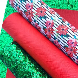 May include: Three sheets of fabric for crafting projects. One sheet is red, one is green glitter, and one is white with black stripes and a red floral pattern.