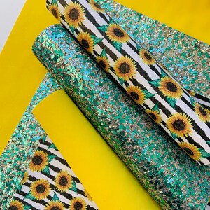 May include: Three sheets of fabric with a sunflower pattern. One sheet is black and white stripes with yellow sunflowers, another is green glitter, and the last is yellow.