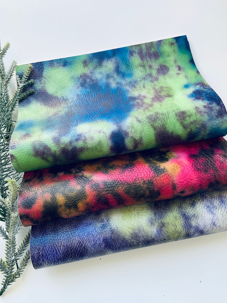 Puede incluir: Tres piezas de tela con patrones de tie-dye en verde, rosa y azul.