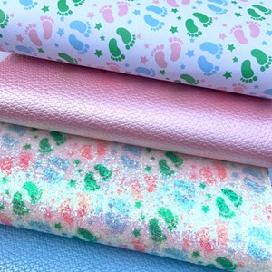 May include: Four fabric swatches, each with a different pattern. The top swatch is white with green and pink footprints and white stars. The second swatch is a solid pink with a textured surface. The third swatch is white with a pink, green, and blue glitter pattern. The bottom swatch is a solid light blue with a textured surface.