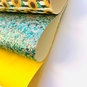 May include: Three rolls of fabric, one with a sunflower pattern, one with green and silver glitter, and one solid yellow.